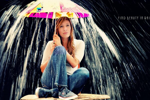 Девушка прячется под зонтом от потока воды