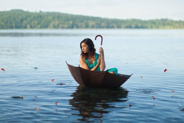 A girl is floating on the lake in an umbrella