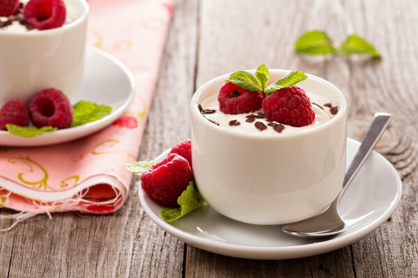 Tasse blanche à la crème garnie de framboises