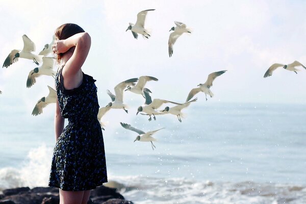 A girl in a black dress on the seashore