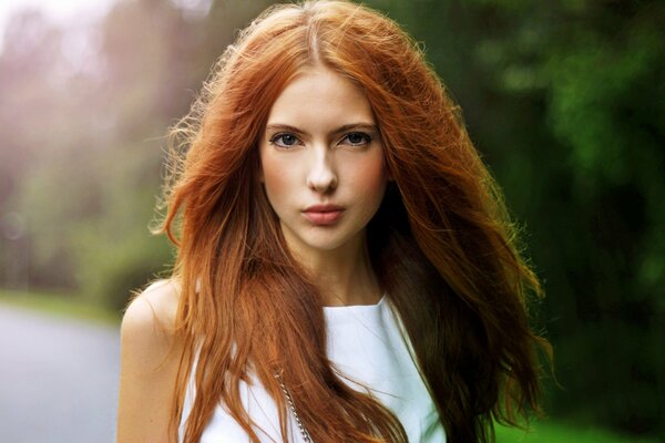 Bella ragazza con i capelli rossi vicino alla foresta