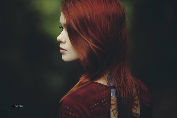 Rousse fille se tient le dos au photographe