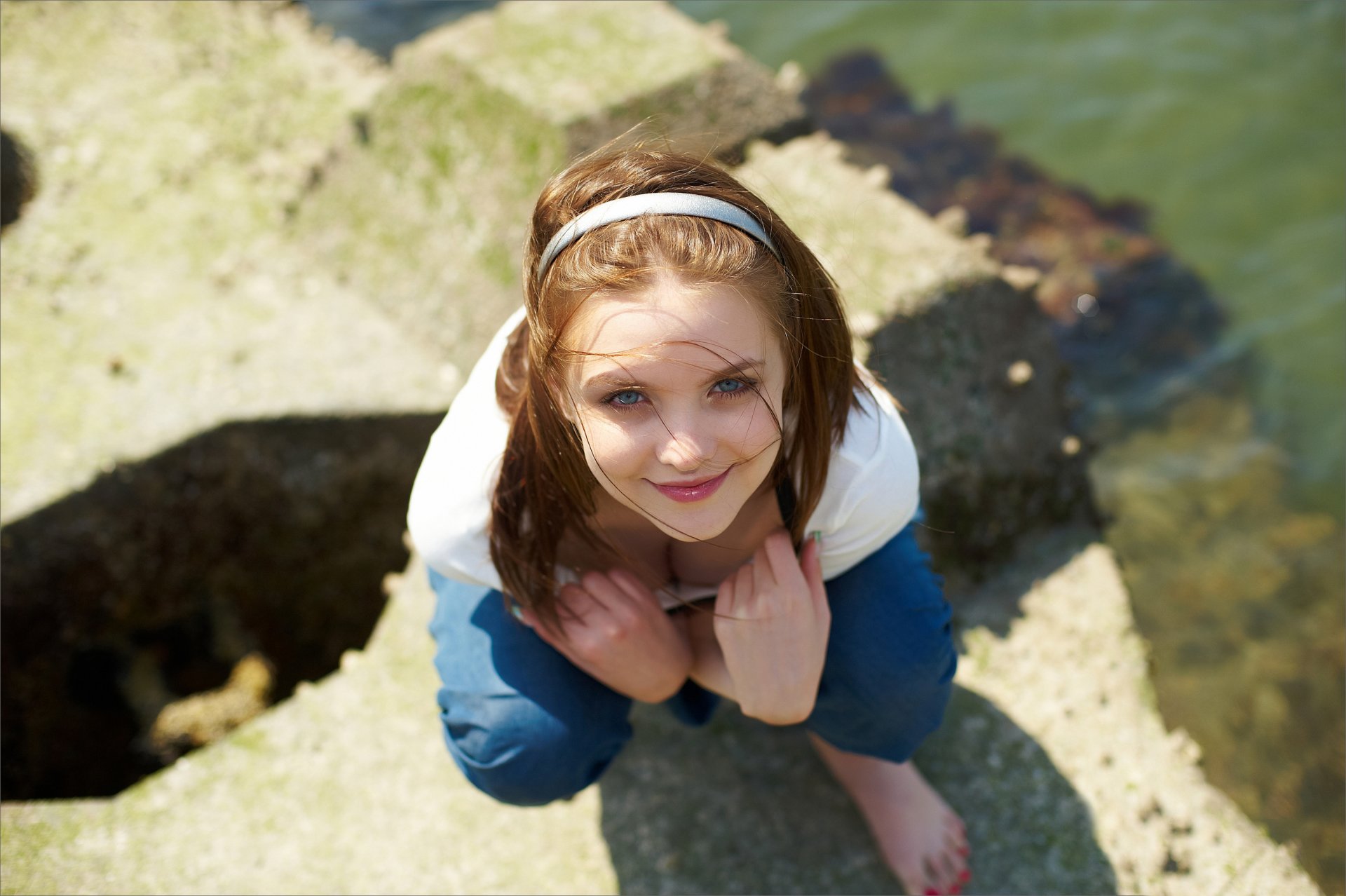 girl brown-haired hoop smile look t-shirt stone water wind