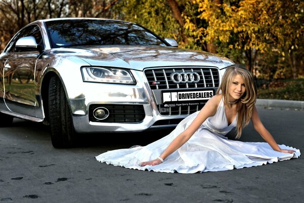 Audi and a girl in white on the background of autumn