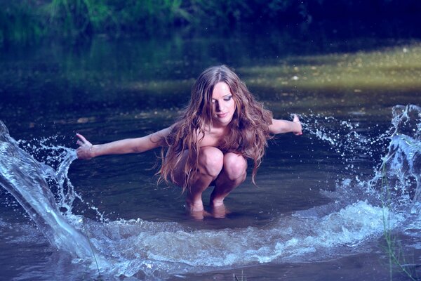 Mädchen mit lockeren Haaren spielt mit Wasser