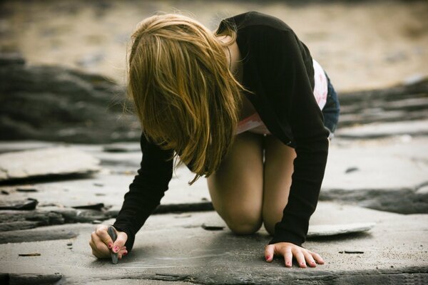 Düsteres Foto Mädchen schreibt auf Asphalt