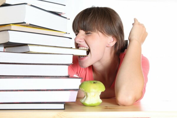 La chica de la manzana y una pila de libros de estudio