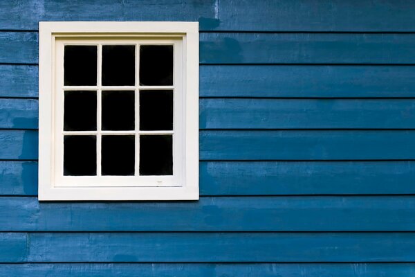 A white window in a blue house