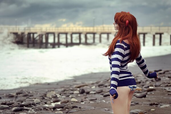 Рыжеволосая девушка наслаждается на пляжу морем