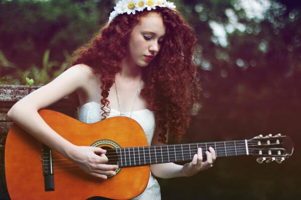 Rousse fille joue de la guitare