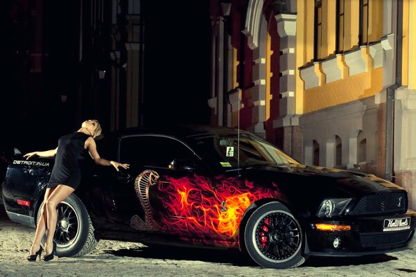 A girl in a black dress on a car