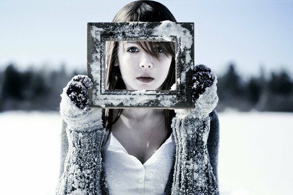 The face of a girl holding a winter frame in her hands