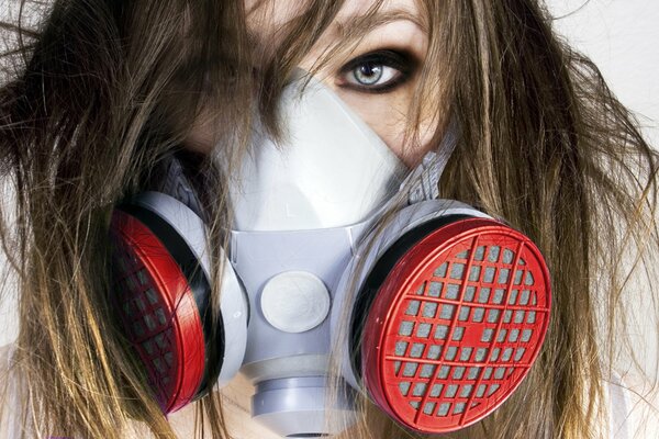 A disheveled girl in a respirator looks straight