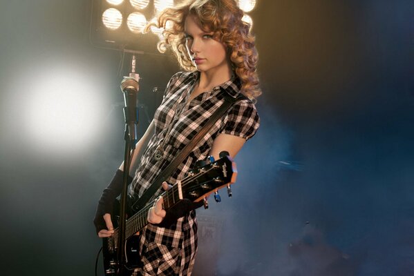 Taylor Swift con la chitarra sul palco