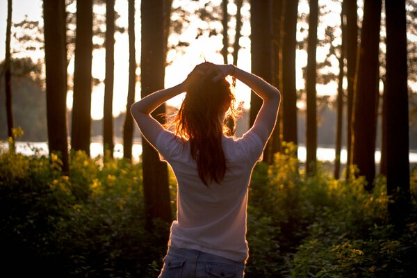 Ragazza al tramonto nella foresta