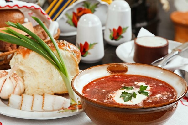 Schönes Foto mit roter Suppe. Köstlicher Borschtsch mit saurer Sahne und Brot