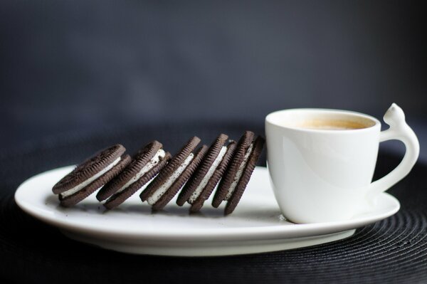 Coffee for breakfast in a white cup and chocolate cookies