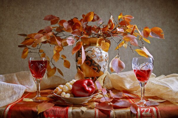 Nature morte de feuilles jaunes, verres de vin et fruits