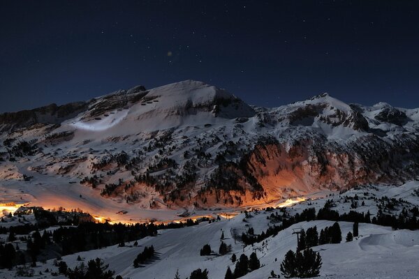 Strada di montagna notturna illuminata dalla luce arancione delle lanterne