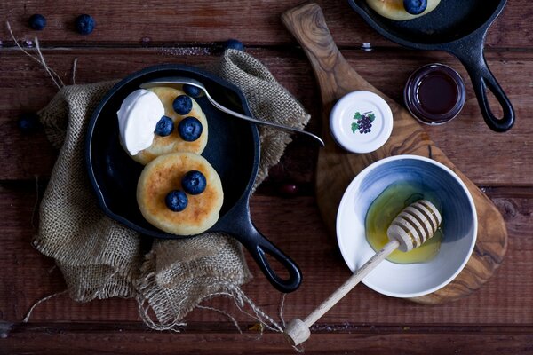 Pfannkuchen mit Blaubeerbeeren und saurer Sahne serviert