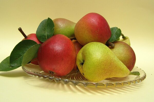 Peras frescas en un plato sobre un fondo amarillo