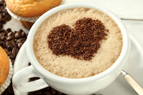 Taza de café con corazón de chocolate y cupcakes
