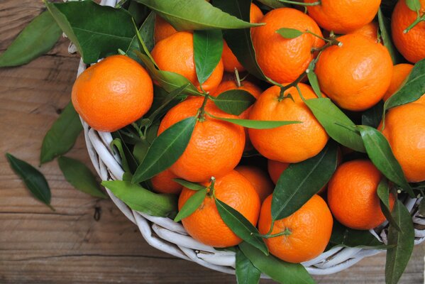 Naranjas cosechadas con hojas en un plato sobre la mesa