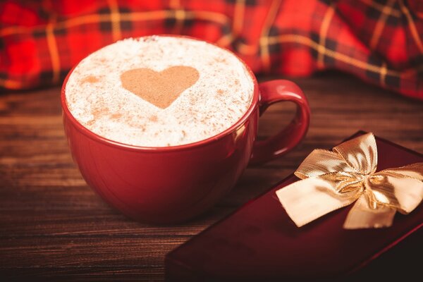 Roter Cappuccino-Becher und Geschenk