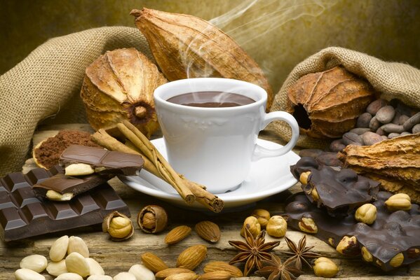 Tazza di caffè con foschia. Circondato da noci e cioccolato