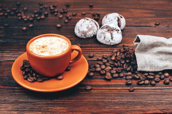 Caffè del mattino su uno sfondo di chicchi sparsi su un tavolo da un sacchetto. a