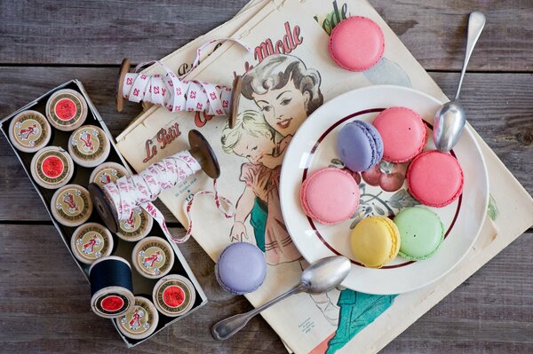 Galletas multicolores en un plato con dos cucharaditas