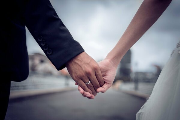 Marido y novia tomados de la mano