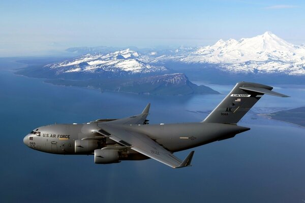 Un Boeing C-17 negro vuela cerca de las montañas