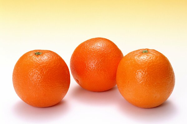 Drei helle Orangen auf weißem Hintergrund