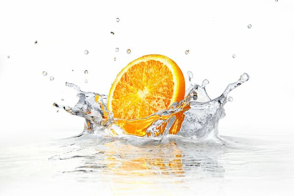 Refreshing orange falls into the water