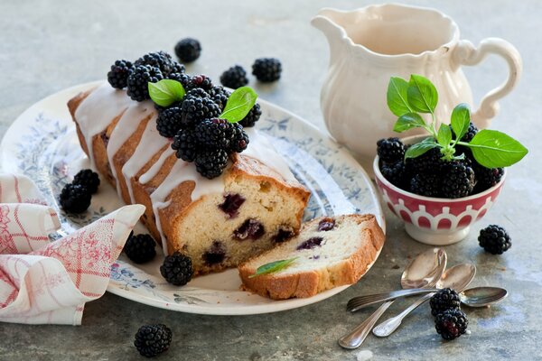 Berry cupcake with blackberries on a plate decorated with mint