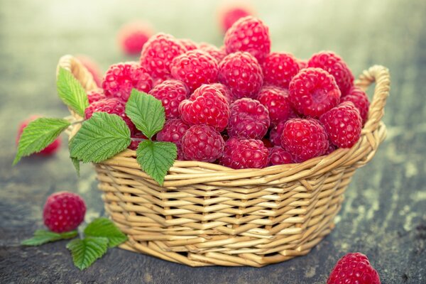 Juicy raspberries with mint in a basket