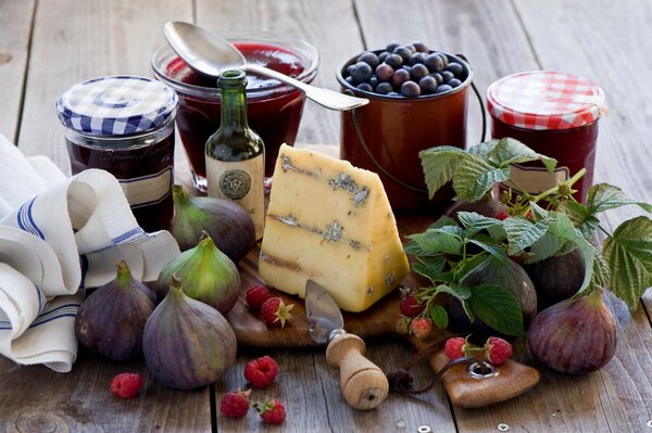 Natura morta di formaggio, fichi, marmellata e bacche