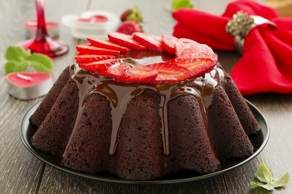 Cupcake décoré de glaçage et de fraises, sur fond de serviette et de bougies