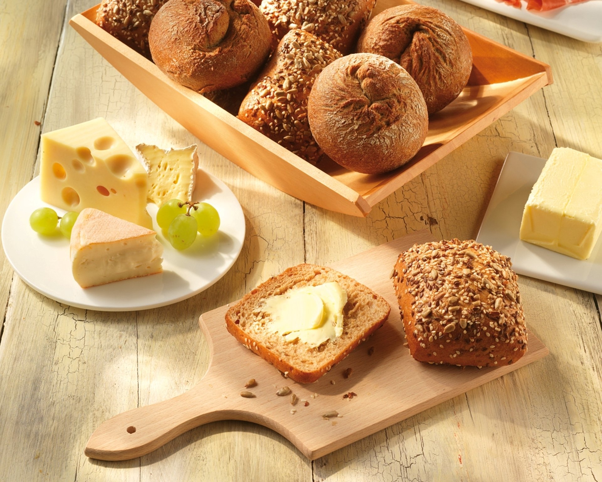 buns bread oil cheese grapes sesame seeds food board