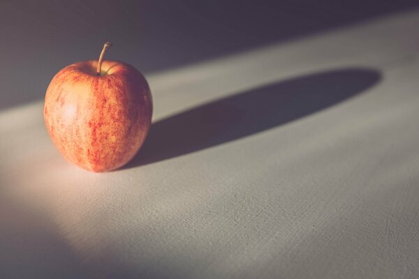 Manzana roja solitaria en un mantel blanco