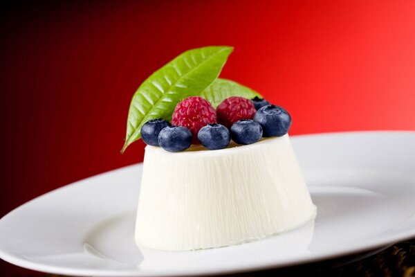 Snow-white dessert with blueberries and raspberries