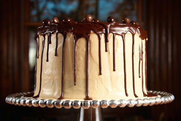 Gâteau blanc dans un glaçage au chocolat sur un stand