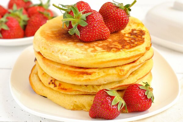 Saucer with thick pancakes and berries