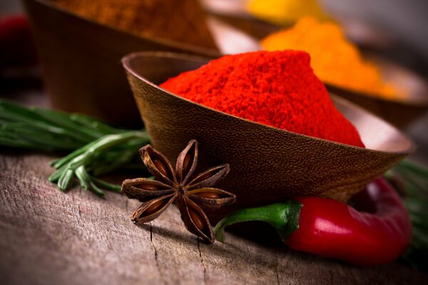 Spices in a wooden cup cardamom and red pepper