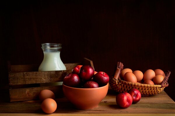 Manzanas rojas y leche con huevos sobre un fondo negro