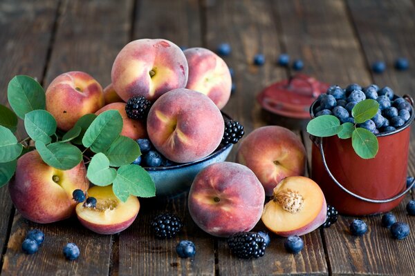 Ripe peaches and a bucket of blueberries