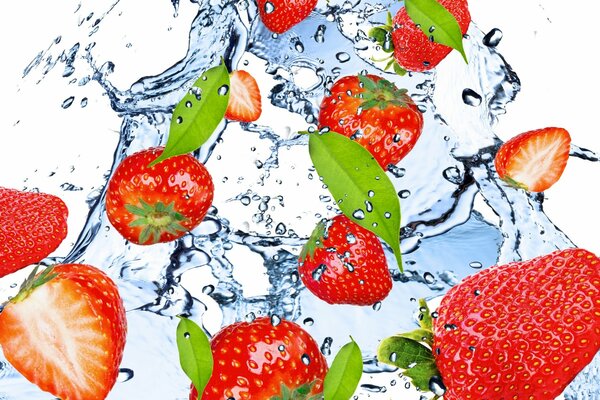 Erdbeeren in einem Strahl von frischem Wasser mit Spritzern