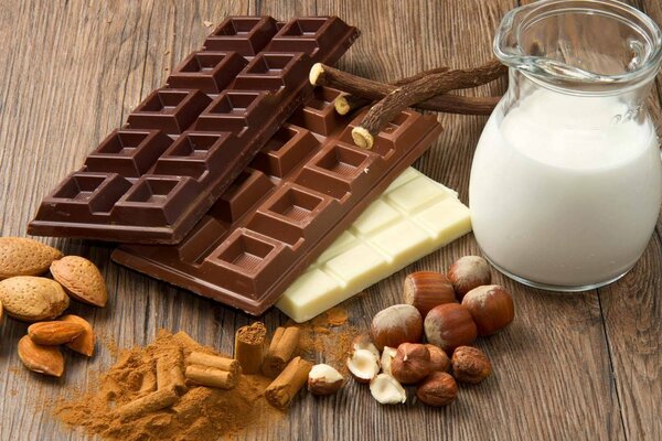 Chocolat, noix, cannelle et lait sont debout sur la table