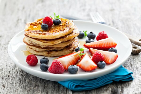 Frittelle appetitose con bacche su un piatto